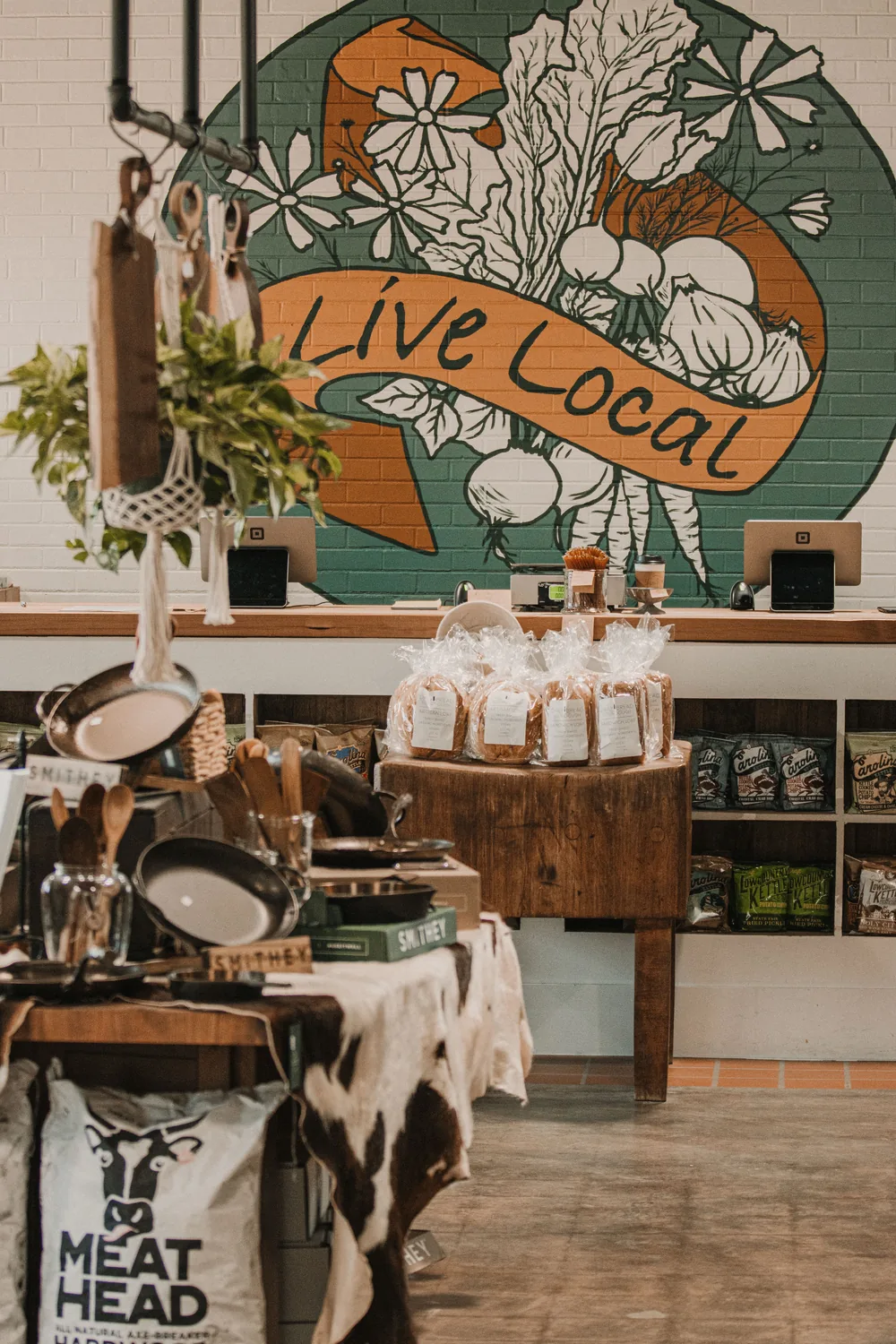 A warm local shop with a hand-painted “Live Local” mural behind the counter